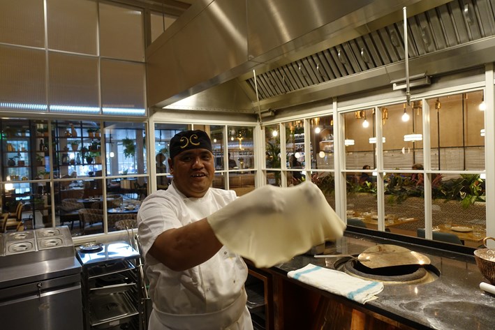 chef tossing roti dough